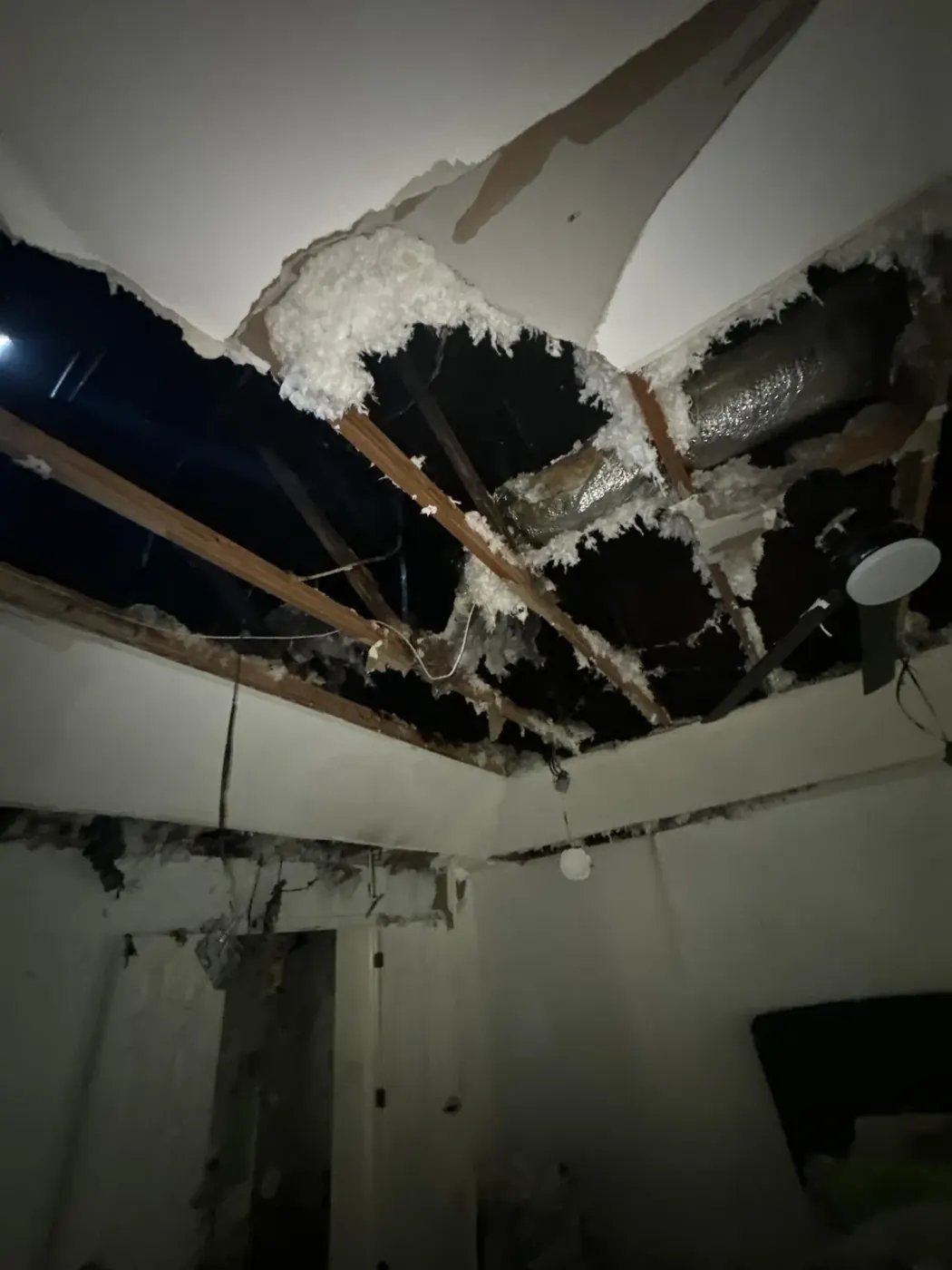 Burned-through ceiling and exposed joists after a house fire in Lawrenceville, GA
