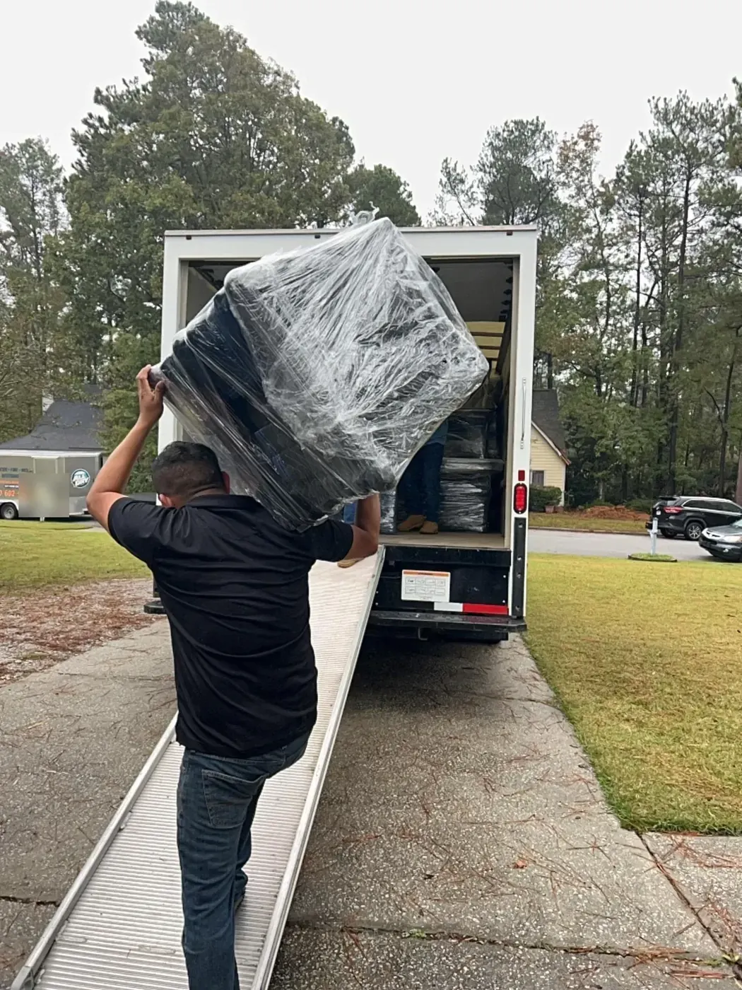 All Dry crew carrying shrink-wrapped furniture to the pack-out truck